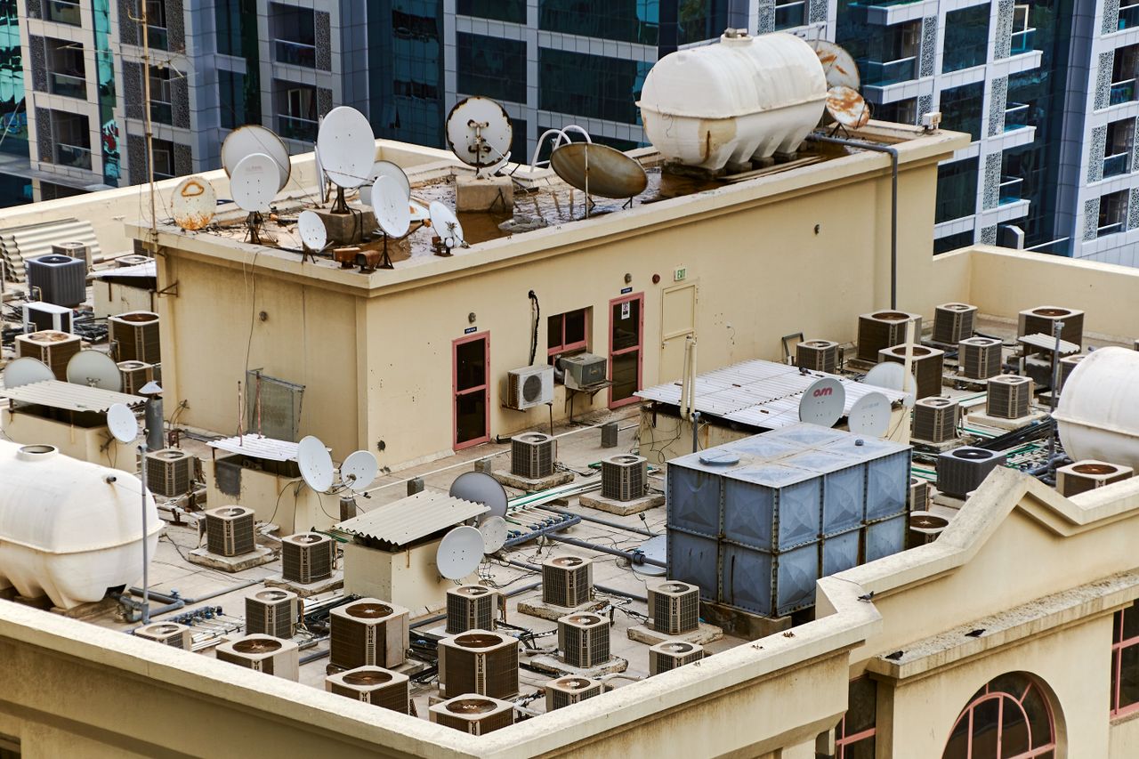 gallery-3 Captured from above, this urban rooftop features satellite dishes, water tanks, and HVAC units, showcasing city infrastructure.
