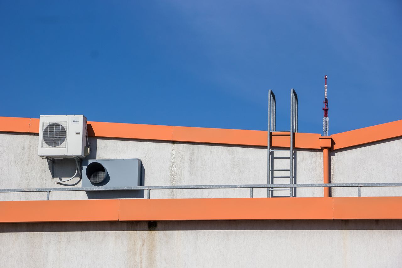 services-01 Rooftop view with HVAC unit, ladder, and clear sky background.
