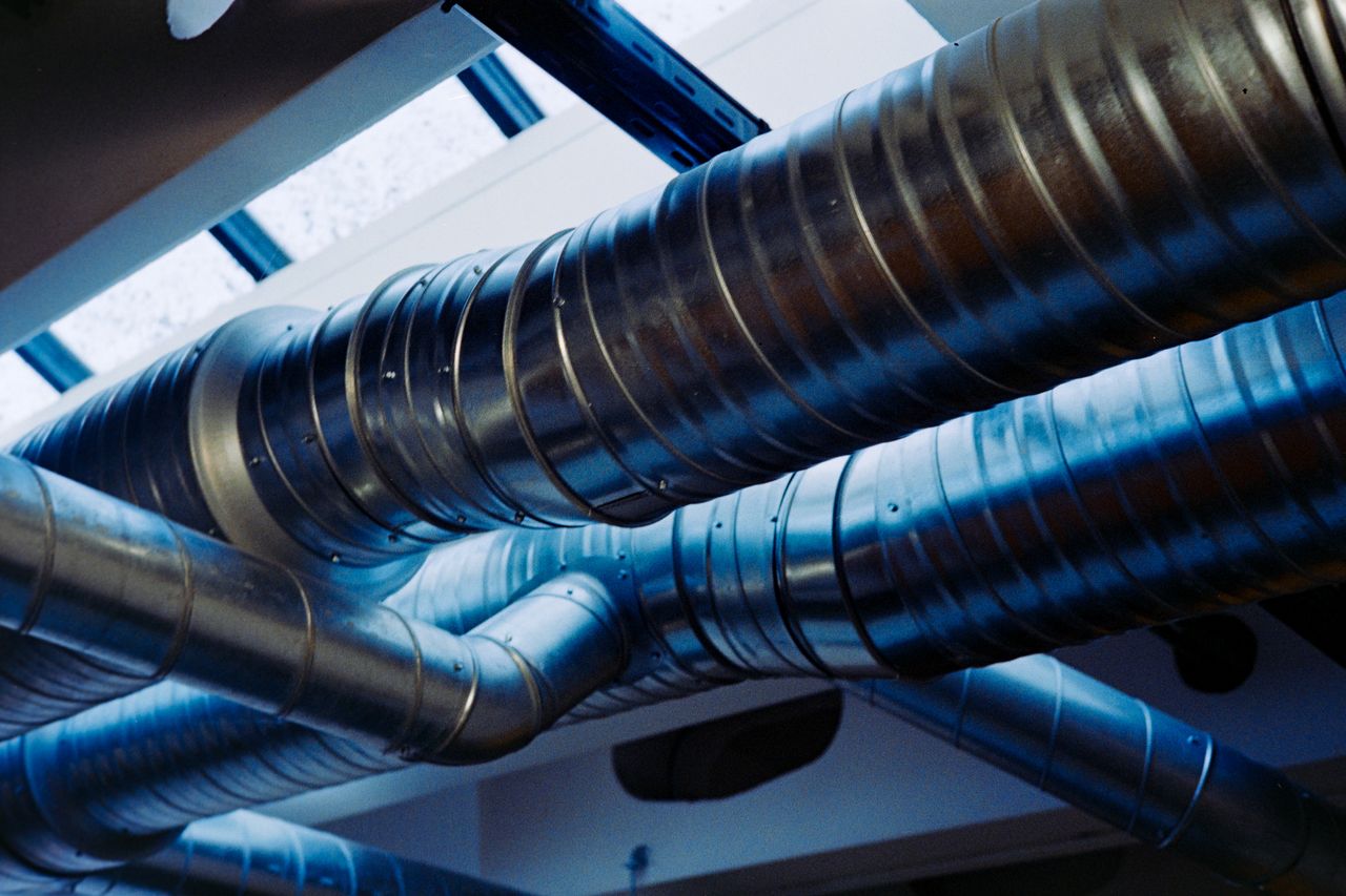about-01 Close-up of a modern metallic ventilation system in an industrial setting.